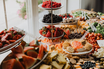 Colorful Grazing Table with Fresh Berries, Watermelon, Pineapple, Crackers, Cheese, and Veggies for Upscale Event Catering and Party Food Display Inspiration