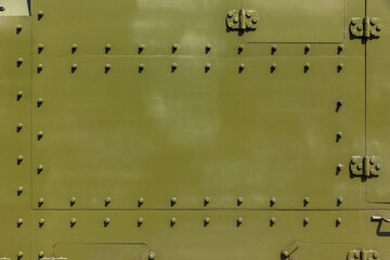 Abstract industrial background texture with bolts of khaki steel wall