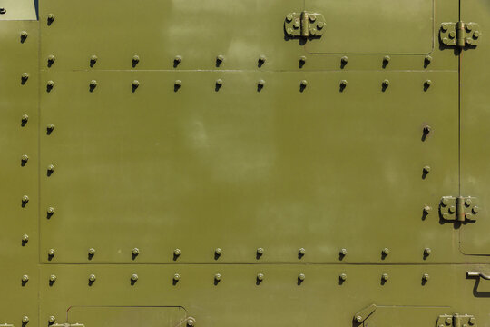 Abstract industrial background texture with bolts of khaki steel wall