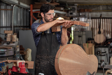Luthier is working on the neck of a classical guitar