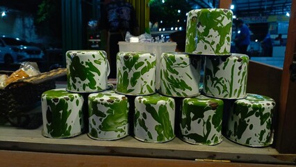 A stack of vintage coffee mugs, unique pattern, in indonesian called blirik mug, stand of chocolate drinks
