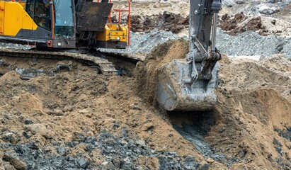 Close-up view of an excavator bucket excavating soil