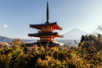 Naklejka premium A traditional Japanese pagoda beautifully set against the majestic backdrop of Mount Fuji
