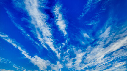 A vibrant blue sky with wispy clouds symbolizes serenity and environmental awareness, ideal for Earth Day promotions