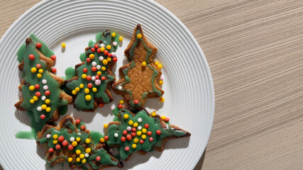 Festive green-iced Christmas tree cookies with colorful sprinkles on a plate celebrate the holiday season and culinary creativity