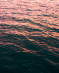 The lake water with small waves from the cool breeze and the glow of the beautiful sunset. 
