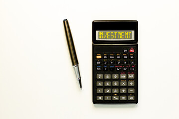 Investment symbol. Concept word Investment on beautiful black calculator. Beautiful white paper background. Beautiful black pen. Business investment concept. Copy space.