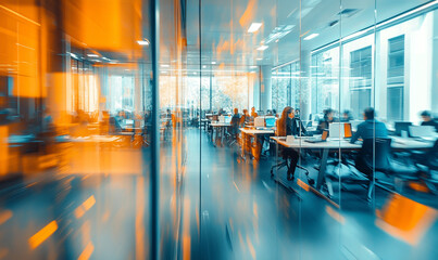 A modern office space with busy employees working at desks featuring an orange and blue color scheme