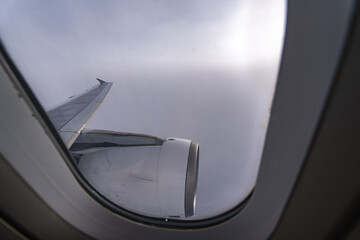View of the clouds and blue sky from an airplane window.