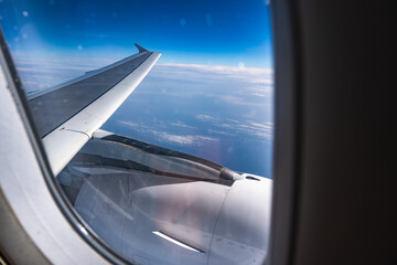 View of the clouds and blue sky from an airplane window.