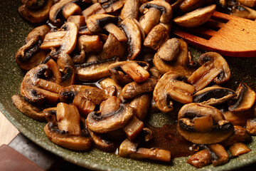 fried mushrooms in a frying pan, with a wooden fork, homemade, no people,