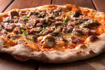 Pizza alla boscaiola condita con salsiccia di maiale e funghi porcini, cibo italiano 