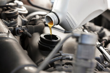 Pouring motor oil into car engine, closeup