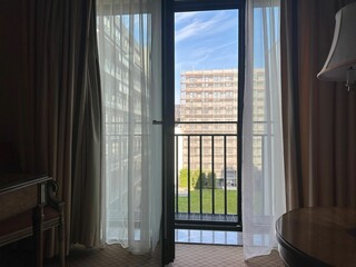Fototapeta premium View on hotel garden through open balcony door