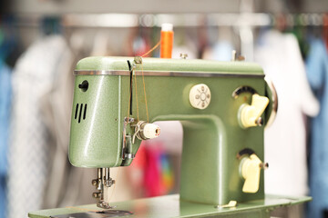 Vintage sewing machine with thread in workshop, closeup