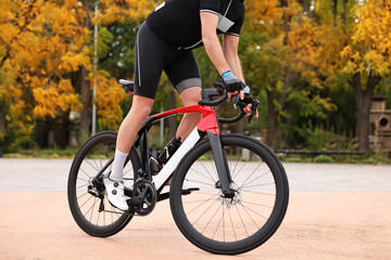 Fototapeta premium Athletic man with helmet riding bicycle outdoors, closeup