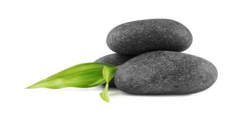 Spa stones and green leaves isolated on white