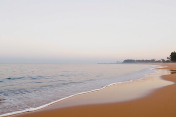 Obraz premium Tranquil Sunrise Over Serene Beach with Gentle Waves and Soft Sand