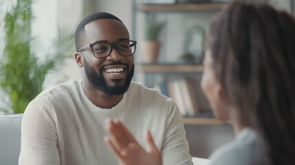 Obraz premium Smiling friendly African American therapist in glasses talking on video call, using sign language, speaking to patient with hearing disability, deafness, showing gestures at screen