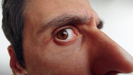 Man Peering Through a Door Viewer with Intense Curiosity