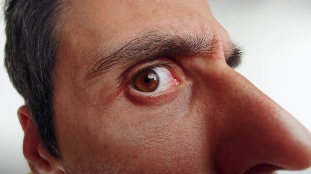 Man Peering Through a Door Viewer with Intense Curiosity