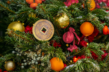 A decorated Christmas tree with Chinese ornaments, gold coins, red pouches
