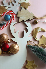 Various cute Christmas ornaments on pale pink background. Selective focus.