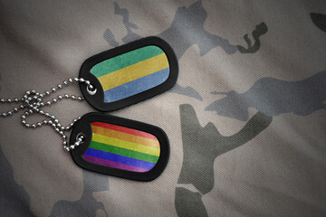 army blank, dog tag with rainbow gay pride flag and gabon on the khaki texture background. military...