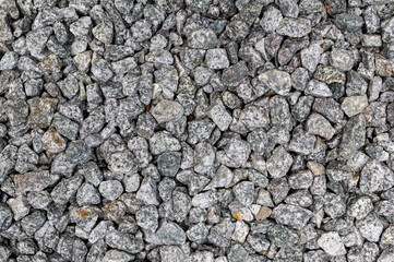 Close-up texture of gray granite gravel stones for construction and landscaping, isolated natural...