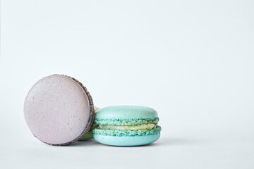 Two colorful French Macarons, cakes with different flavors, mint, apple, currant flavor. dessert, macaroons aquamarine, green, purple color. Copy space for text