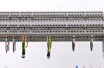 Electrical screw through terminals with connected insulated wires in an electrical switchboard.