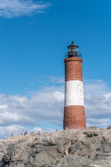 Les Eclaireurs lighthouse on rocky island with snowy mountains in Beagle Channel