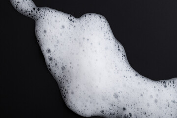 Close up of a soap bubble on a black background. Black foam soap with a white background. Black and white foam lying on a white background. Black soap with white foam lying on the lifestyle.