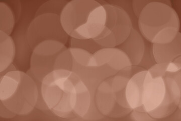 Demonstrating Mocha mousse color of the year 2025. Lights on brown defocus background. Bokeh defocus disco effect. Holiday abstract christmas lights garland.