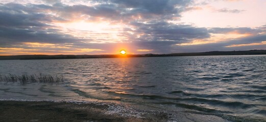 Obraz premium Magical sunset behind the clouds with the beautiful dam. 