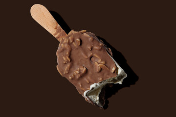 Chocolate ice cream on a stick on brown background