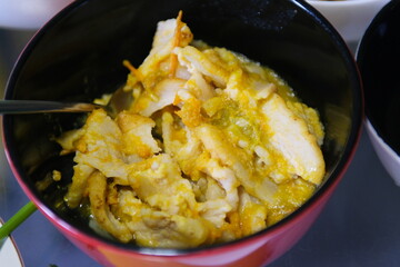 red plate with black lard cut into small pieces with tomato sauce. bacon with yellow tomato sauce