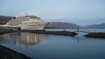 Statek i samotna dziewczyna odbijająca się w wodach portu w Akureyri. Północna Islandia.  © onlytraveler
