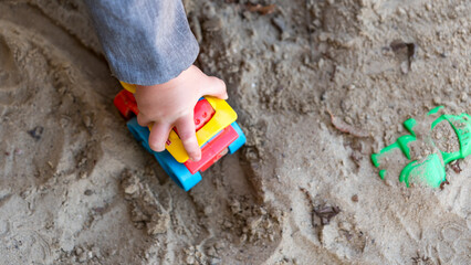 Cutout of a toddler playing with toys in a sandbox