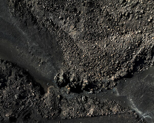 View from above on the road among black basalt rocks and lava formations.