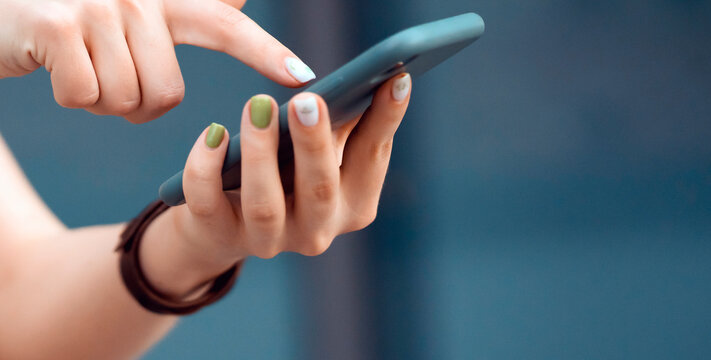 Girl is holding a smartphone in her hands closeup view.
