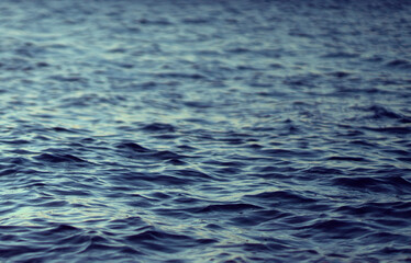 Naklejka premium A water surface with small waves, a beautiful ocean closeup.