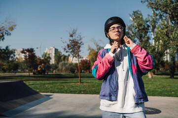 Stylish skater adjusting helmet in skate park, getting ready to ride