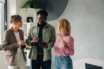 Business people using tablet and discussing work in office