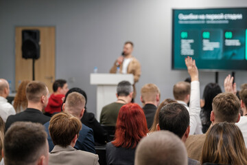 Focused audience listens to speaker during seminar. Interactive discussion and participation evident.