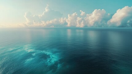 Aerial view of tranquil sea with vibrant horizon under peaceful clouds showcasing nature's serene beauty and calm water reflections
