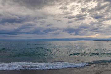 Sandy shore of sea against the sky in overcast morning