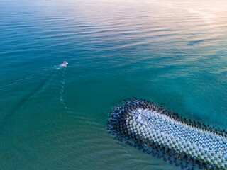 Aerial View of Coastal Breakwater with Small Boat. High-angle, full shot of a tranquil coastal scene. Karasu Sakarya Adapazari Turkiye Turkey Drone shot travel holiday advertisement photo high quality