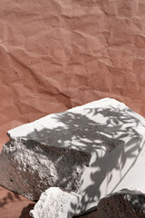 Demonstrating color of the year 2025. Mocha mousse color swatch. Creative grey stone podium for products on brown, beige, sepia craft paper background.