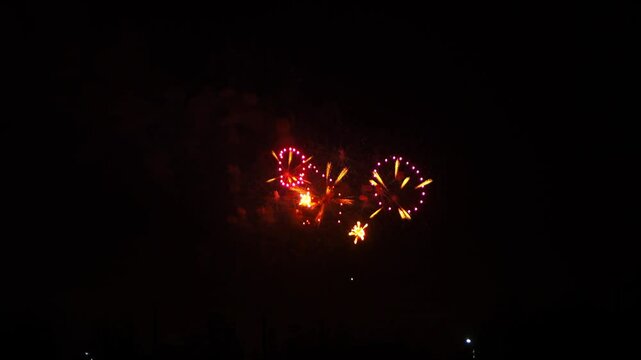 gold red orange sparks scatter fireworks on black night sky. General plan